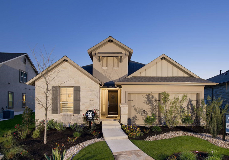 exterior of a one story home with beige stucco and light beige stone and dormer