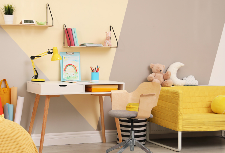 A bright and vibrant children’s room features plush toys, cozy furniture and a desk with a collection of school supplies.