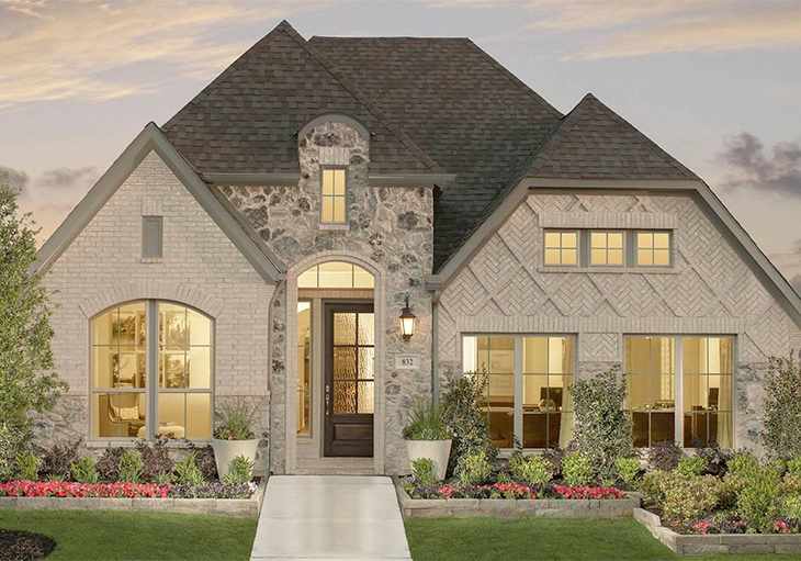 This Perry Homes’ Design 2504W featuring light brick arranged in a herringbone pattern and a natural stone façade can help in