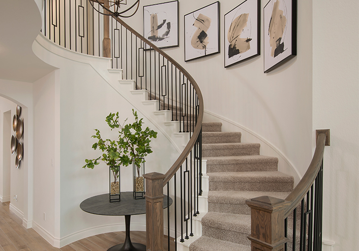 Open entryway with wood flooring, natural light and neutral rug and table décor in a Perry home.