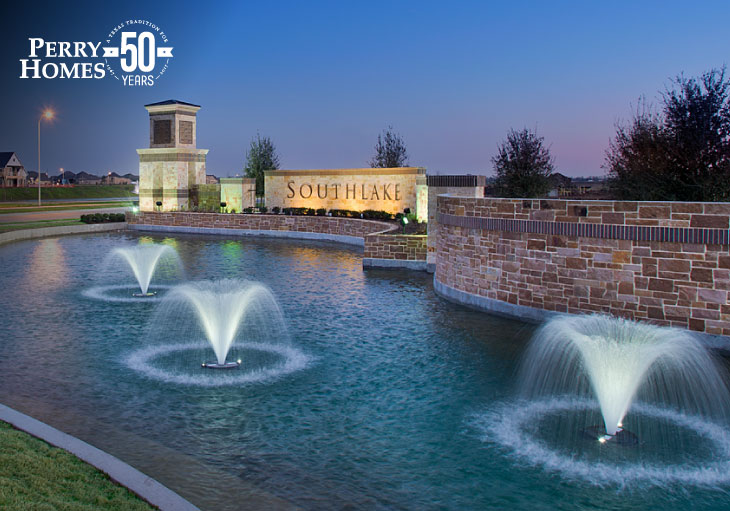 southlake community monument with pond and three fountains illuminated at night